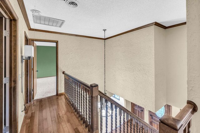 4554 Nicklaus Ct, Decatur, IL 62526 - corridor featuring a textured wall, a textured ceiling, hardwood / wood-style flooring, an upstairs landing, and ornamental molding