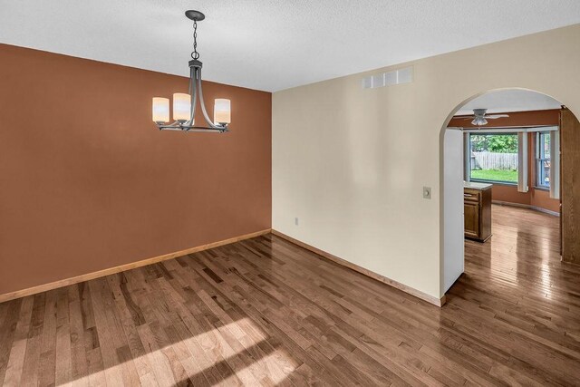 4554 Nicklaus Ct, Decatur, IL 62526 - unfurnished room with arched walkways, wood finished floors, a chandelier, and baseboards