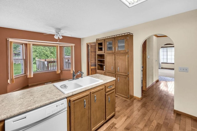 4554 Nicklaus Ct, Decatur, IL 62526 - kitchen featuring white dishwasher, a sink, ceiling fan, arched walkways, and brown cabinets