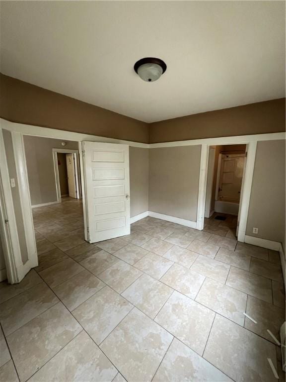 249 N 17th St, Decatur, IL 62521 - unfurnished bedroom with baseboards and light tile patterned flooring