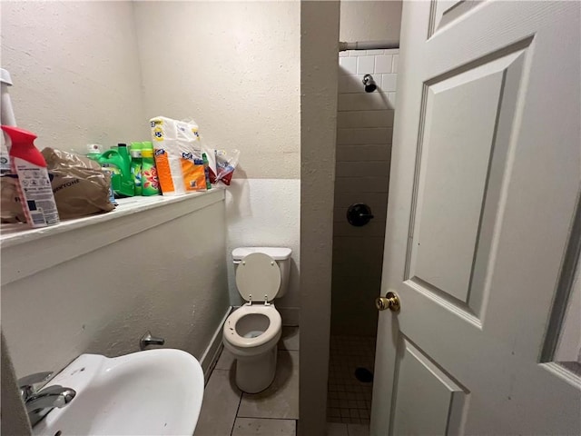bathroom with a sink, tile patterned floors, and toilet