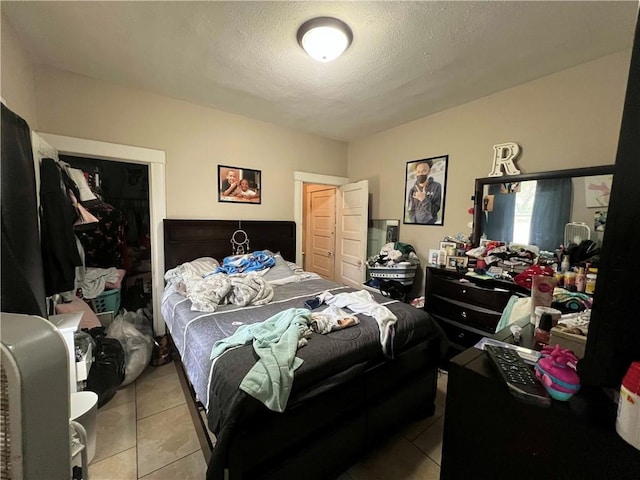 bedroom with tile patterned flooring and a textured ceiling