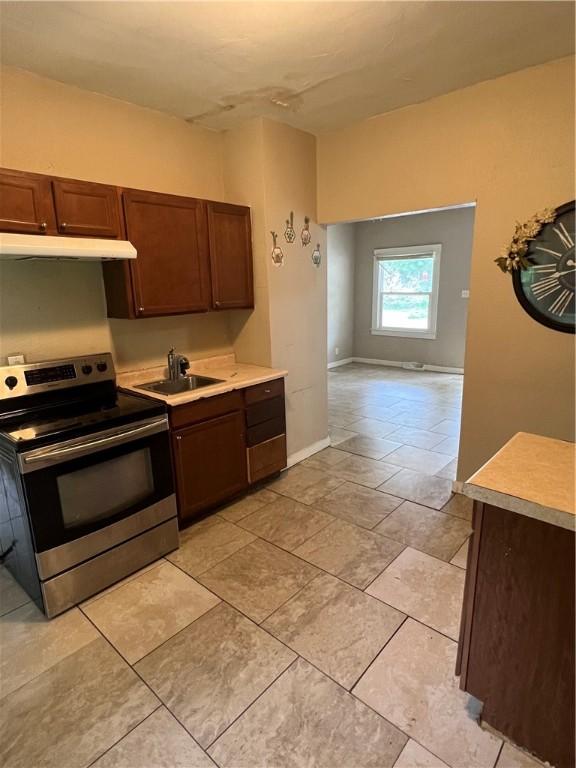 249 N 17th St, Decatur, IL 62521 - kitchen featuring electric range, a sink, under cabinet range hood, and light countertops