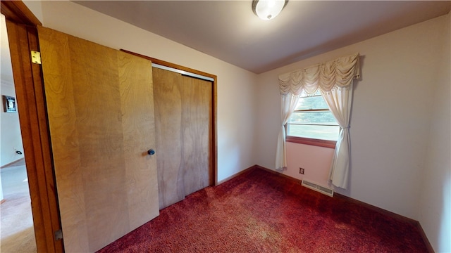 unfurnished bedroom featuring carpet floors and a closet