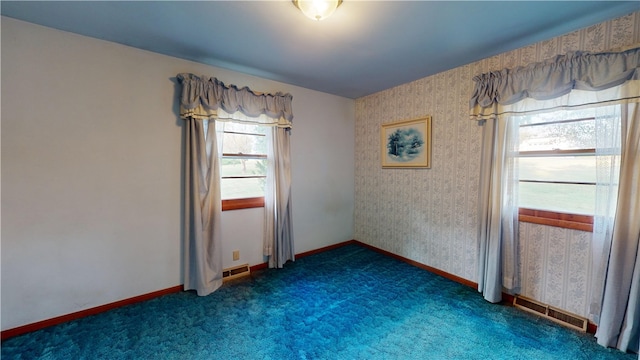 spare room featuring dark carpet