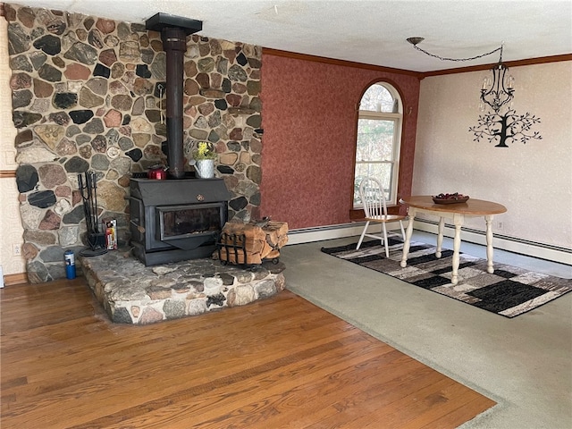 dining space with carpet flooring, a wood stove, a textured ceiling, and ornamental molding