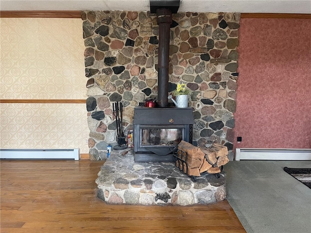 interior details featuring wood-type flooring, a baseboard radiator, a wood stove, and ornamental molding