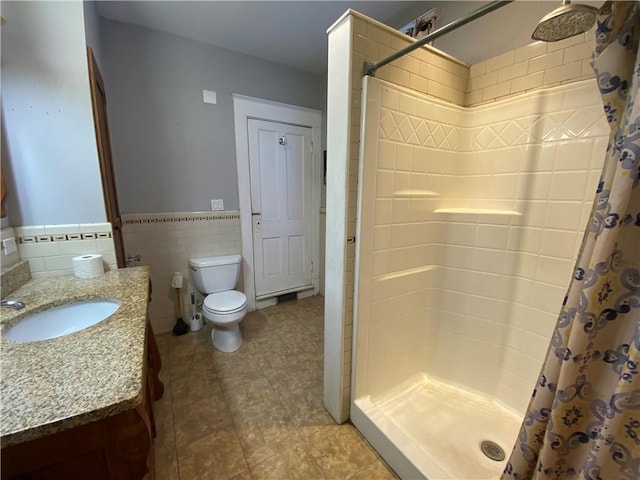 1105 Edgar Ave, Mattoon, IL 61938 - bathroom with a tile shower, vanity, tile patterned floors, wainscoting, and tile walls