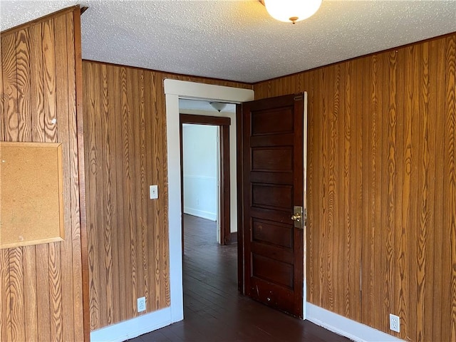 764 10th St, Charleston, IL 61920 - spare room featuring wooden walls, a textured ceiling, and dark wood finished floors