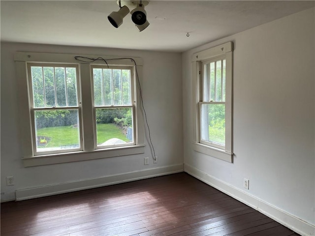 764 10th St, Charleston, IL 61920 - spare room featuring dark wood-type flooring and baseboards