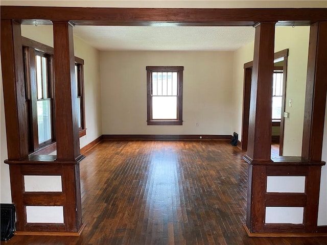 764 10th St, Charleston, IL 61920 - spare room with dark wood-style flooring and decorative columns