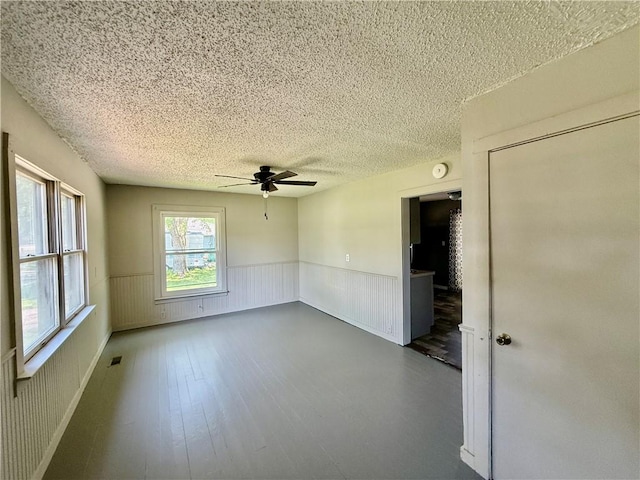 1250 S Lake Ridge Ave, Decatur, IL 62521 - unfurnished room featuring a wainscoted wall, ceiling fan, a textured ceiling, wood finished floors, and a smoke detector