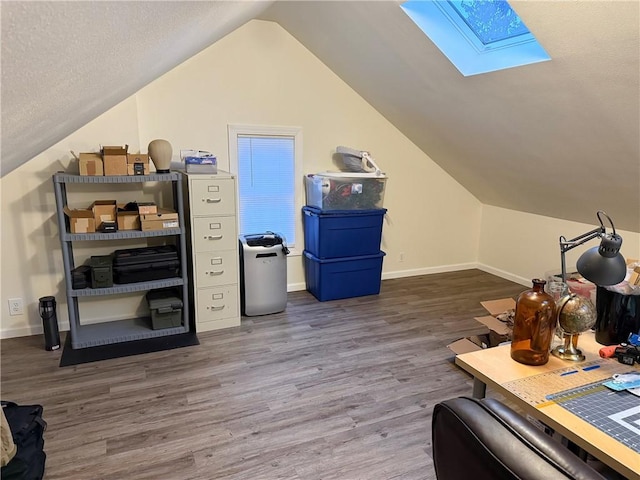 bonus room featuring vaulted ceiling with skylight, baseboards, and wood finished floors