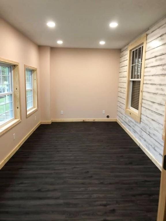 spare room with baseboards, recessed lighting, and dark wood-style floors
