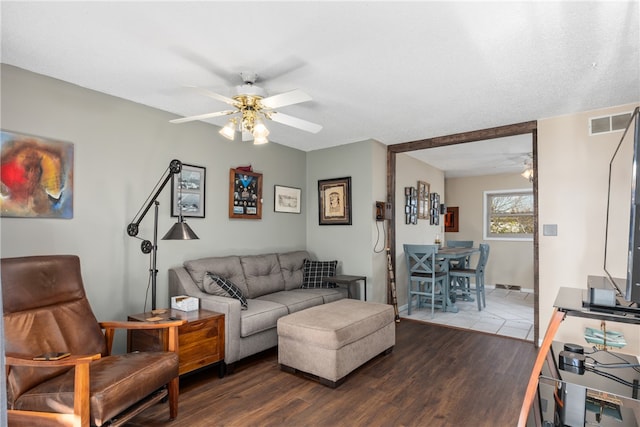 living room with hardwood / wood-style flooring, ceiling fan, and a textured ceiling