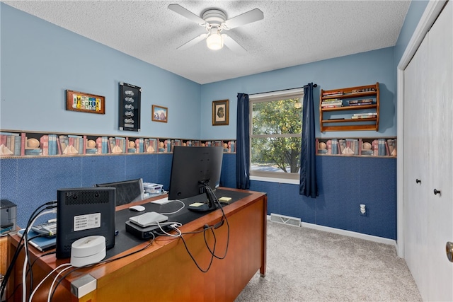 office space with carpet, a textured ceiling, and ceiling fan