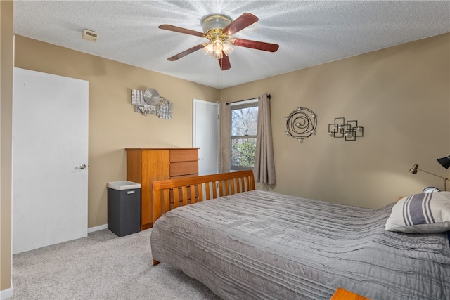 bedroom featuring a textured ceiling, ceiling fan, and light carpet