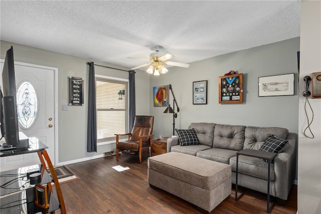 living room with ceiling fan, dark hardwood / wood-style flooring, and a textured ceiling