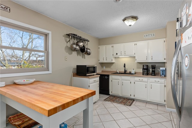 kitchen with white cabinetry, sink, backsplash, light tile patterned floors, and appliances with stainless steel finishes