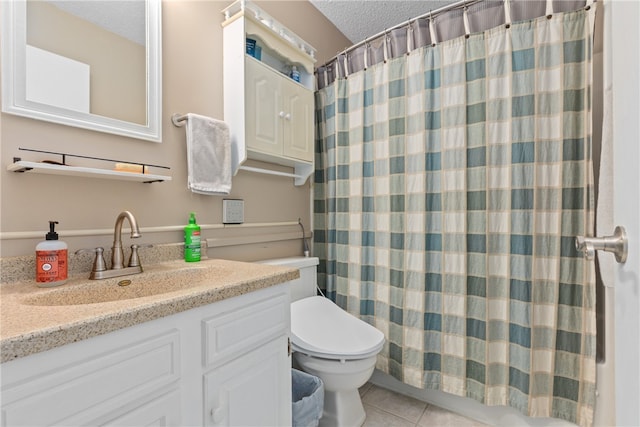 bathroom with tile patterned flooring, vanity, a textured ceiling, and toilet