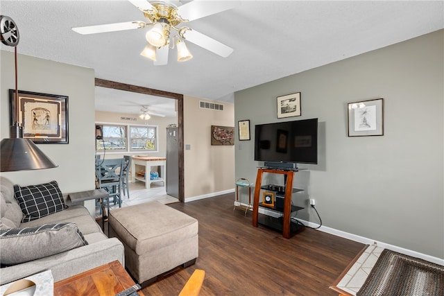 living room featuring a textured ceiling, ceiling fan, and dark hardwood / wood-style floors