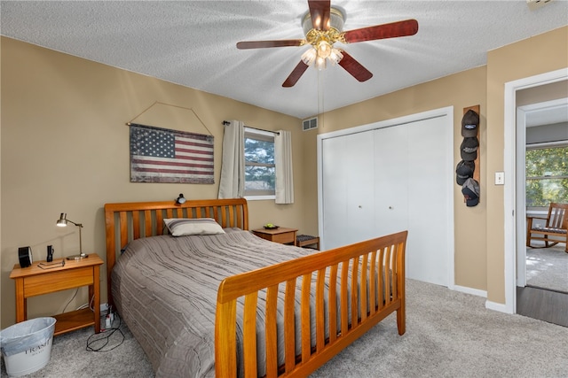 carpeted bedroom featuring multiple windows, ceiling fan, a closet, and a textured ceiling