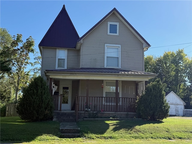 view of front facade with a front yard, an outdoor structure, and covered porch