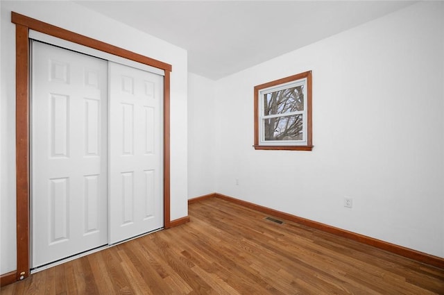 710 E Blackburn St, Paris, IL 61944 - unfurnished bedroom featuring baseboards, wood finished floors, and a closet