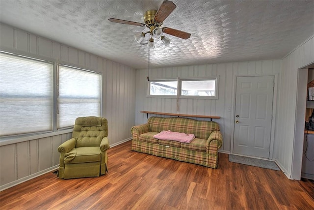 living area featuring a textured ceiling, ceiling fan, and hardwood / wood-style floors