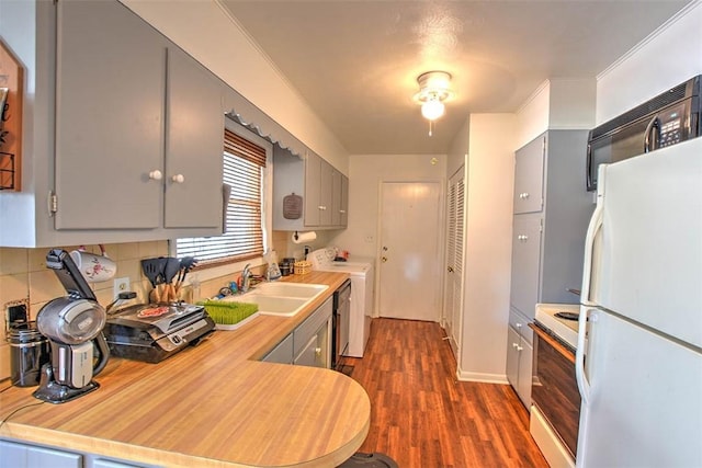 kitchen featuring tasteful backsplash, black appliances, sink, gray cabinetry, and dark hardwood / wood-style flooring