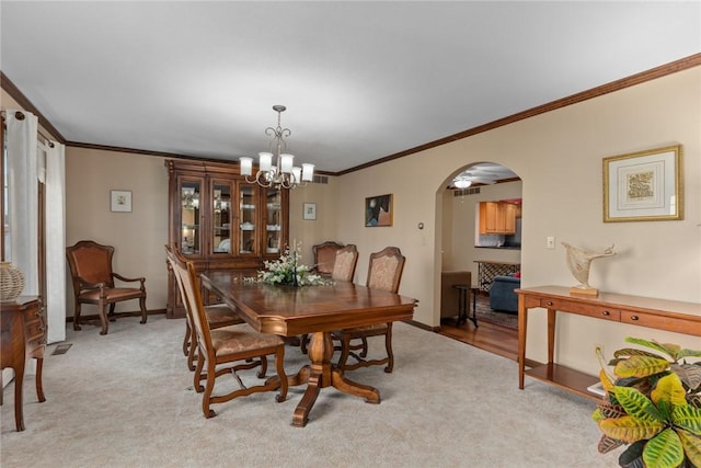 dining area featuring crown molding, arched walkways, an inviting chandelier, and baseboards