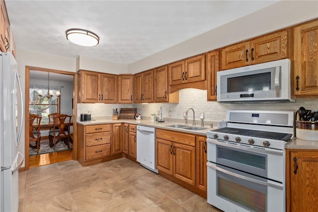9769 Loy Chapel Rd, Effingham, IL 62401 - kitchen with white appliances, a sink, a chandelier, and brown cabinets