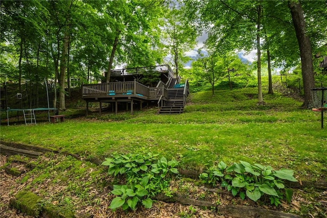 106 E Hawthorne Dr, Effingham, IL 62401 - view of yard with a trampoline, a wooden deck, stairway, and view of wooded area