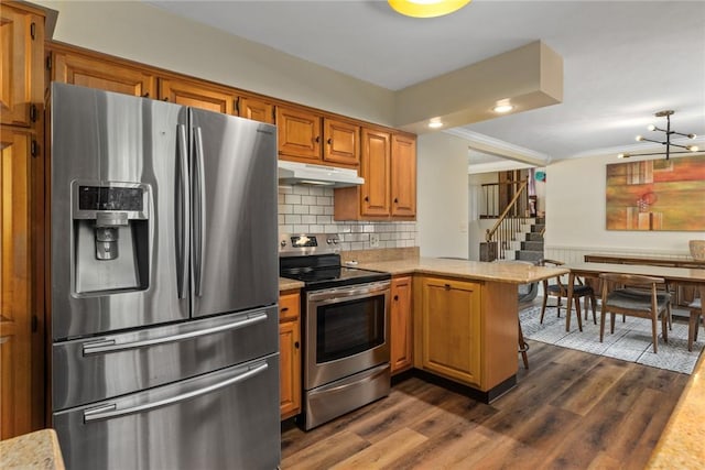 106 E Hawthorne Dr, Effingham, IL 62401 - kitchen with appliances with stainless steel finishes, a peninsula, under cabinet range hood, dark wood-type flooring, and brown cabinets