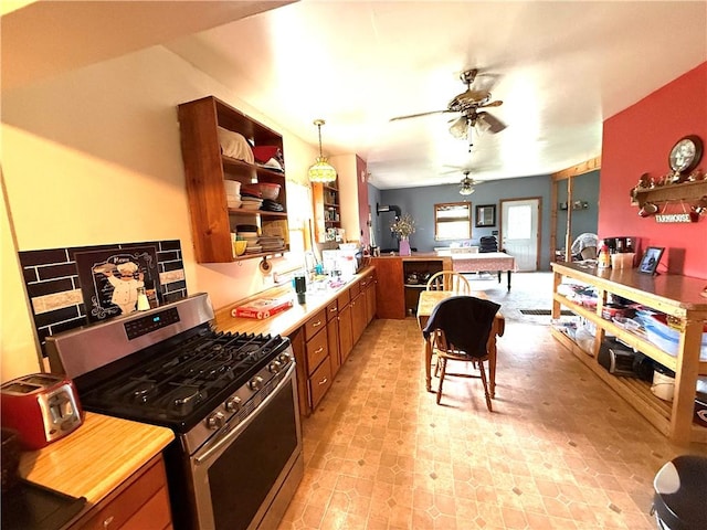 1953 E 4200 N Rd, Rankin, IL 60960 - kitchen with stainless steel gas range oven, a peninsula, brown cabinets, a ceiling fan, and light countertops