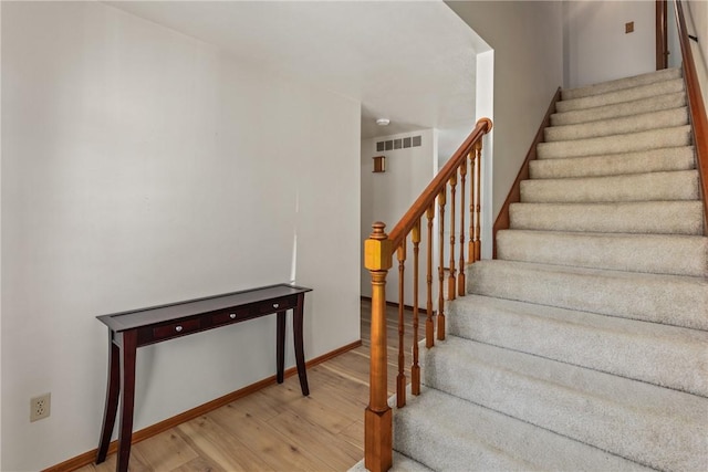 staircase with hardwood / wood-style floors