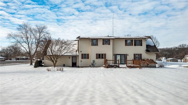 snow covered rear of property with a wooden deck