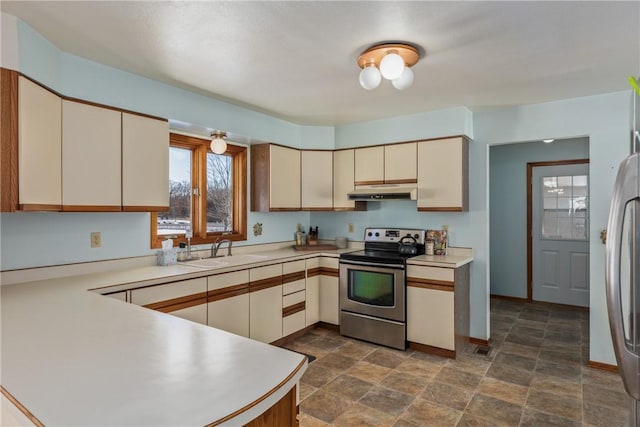 kitchen with stainless steel appliances, kitchen peninsula, sink, and cream cabinetry