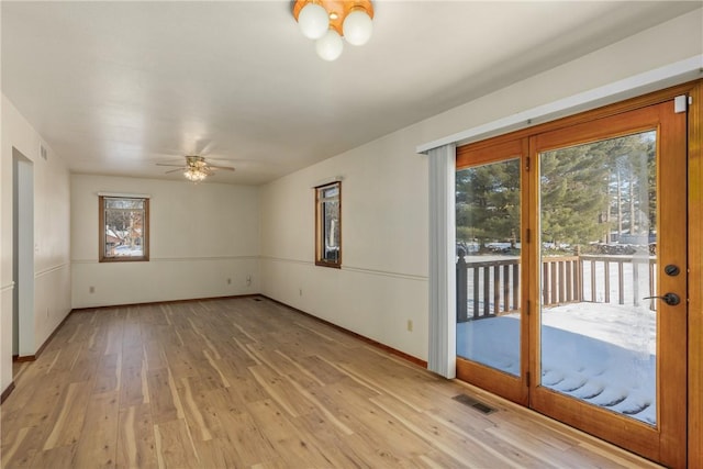 empty room with ceiling fan and light hardwood / wood-style flooring