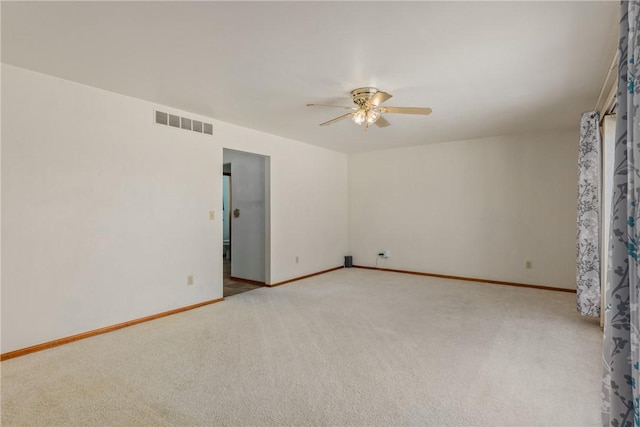 spare room featuring light carpet and ceiling fan