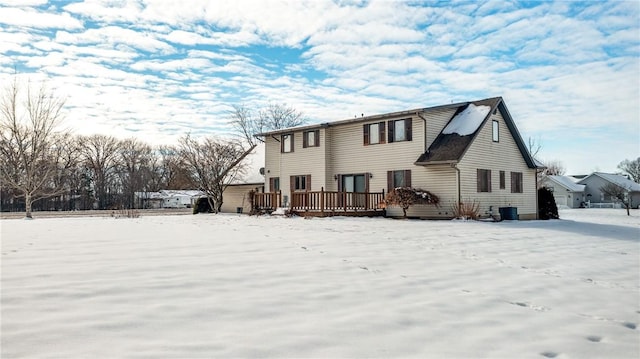 snow covered back of property featuring cooling unit and a deck