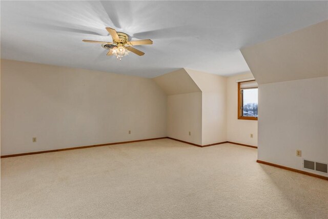 additional living space featuring vaulted ceiling, light carpet, and ceiling fan