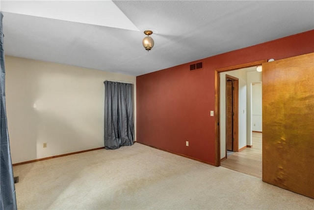 unfurnished room featuring light carpet