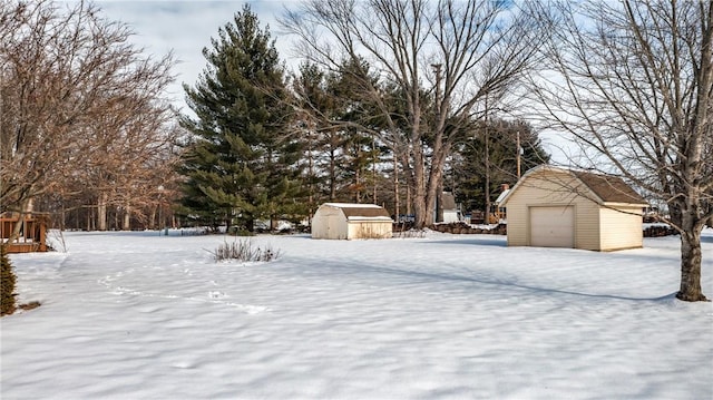 yard layered in snow with a storage shed