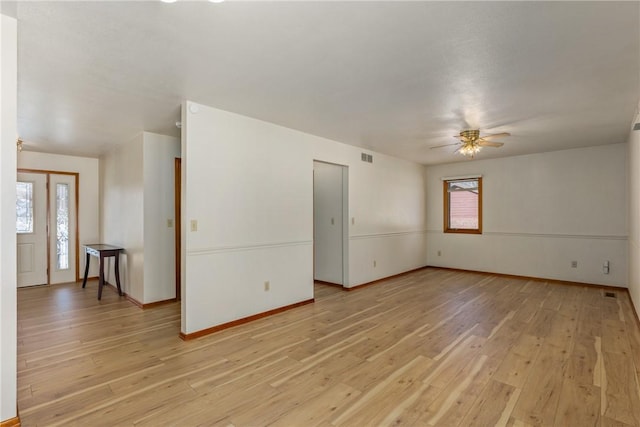 empty room with light hardwood / wood-style flooring, a wealth of natural light, and ceiling fan