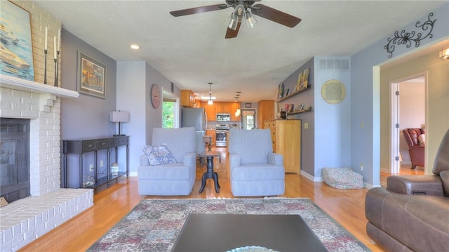 1950 Shore Oak Dr, Decatur, IL 62521 - living room featuring a fireplace, a ceiling fan, light wood finished floors, and recessed lighting