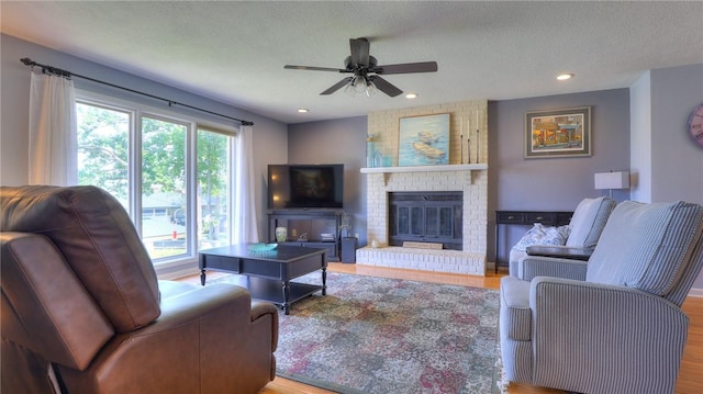 1950 Shore Oak Dr, Decatur, IL 62521 - living area with ceiling fan, wood finished floors, a textured ceiling, a fireplace, and recessed lighting