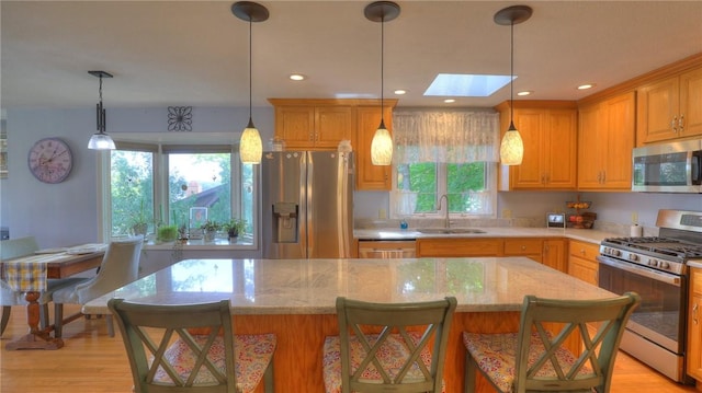 1950 Shore Oak Dr, Decatur, IL 62521 - kitchen featuring appliances with stainless steel finishes, a center island, light stone countertops, recessed lighting, and a skylight
