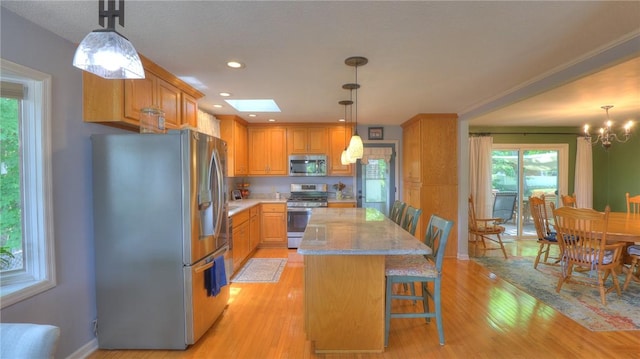 1950 Shore Oak Dr, Decatur, IL 62521 - kitchen with appliances with stainless steel finishes, light wood-style floors, a chandelier, a center island, and recessed lighting