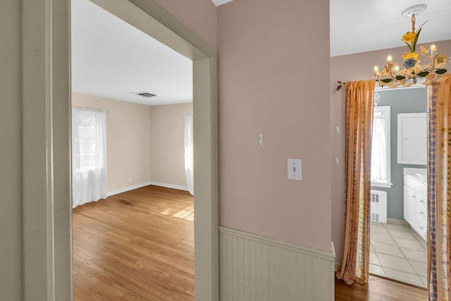530 Powers Ln, Decatur, IL 62522 - corridor featuring wood finished floors, a chandelier, and radiator